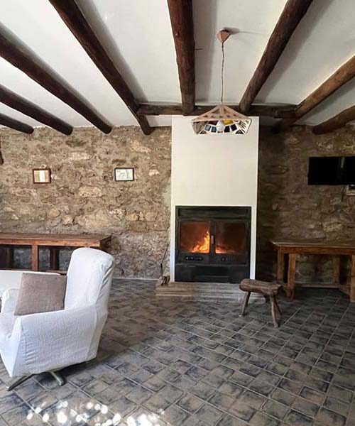 Salón completo con chimenea y TV en Cortijo El Soto